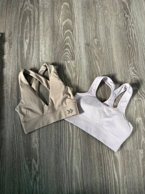 🌷tränings-bh paket | 2 st | XS - ✨ Två superfina tränings-bh:s/sporttoppar i trendiga och neutrala färger – perfekta till gymmet, pilates, promenader eller vardagen 🌸☁️  🌷 Ljuslila ribbad tränings-bh 🏋️‍♀️ Använd fåtal gånger endast 💛 Beige sport-bh med snygg ryggdetalj från lager 157 ✨ Fint skick på båda 📏 Passar XS-S 🫶🏻 Bekväma och sköna med bra stöd  🏋🏻‍♀️🌸☁️🫶🏻✨