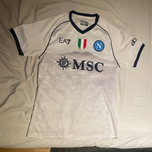 Napoli fotbollströja bortaställ 23/24  - Säljer denna snygga Napoli fotbollströjan då den ej kommer till någon användning. Storlek L sitter mer som M. Skick 9/10 pris går att diskuteras 