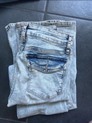 Ljusblå bootcut jeans - Säljer ett par ljusblå bootcut jeans från med snyggt slitna detaljer och kontrastfärgade fickor💘