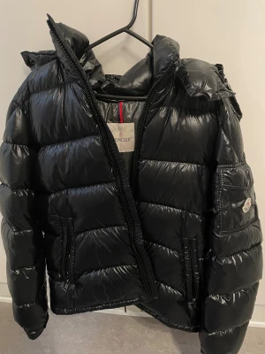 Moncler maya jacka - Säljer en svart pufferjacka från Moncler. Det är storlek L (3). Den är i ny skikt och ser helt ny ut. Säljer den för 5000kr. Nypris på jackan är 18,000kr. 