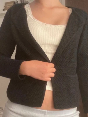 Svart kofta med fickor - Se bilder för noppror + lite damm. Högkvalitets material