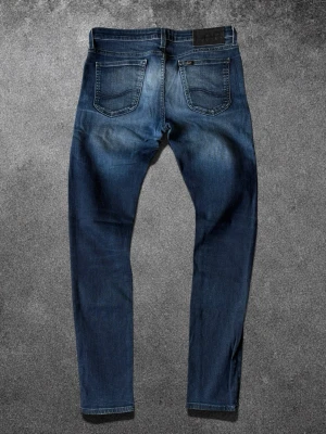 Lee Jeans  - Lee Malone Slim Jeans | Storlek W32/L34 | Använda men i mycket bra skick, inga defekter | Slim fit | Mått: midja 42 cm, längd 105 cm | Skickas snabbt, kan gå ner i pris vid snabb affär  Mvh ActiveResell | REF: LEE-001 