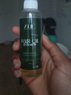 ALIÉ Hair Oil Growth med biotin - ALIÉ Hair Oil Growth är en närande hårolja med biotin, perfekt för dig som vill boosta hårväxten. Kommer i en genomskinlig plastflaska med grön etikett och vitt lock. Oljan är ljusgul och innehåller bland annat solrosolja och mandelolja. Lite mer än två tredjedelar kvar, finns på tredje bilden