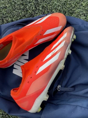 Adidas Crazyfast röda fotbollsskor storleka 45/46 och snören finns med  - Säljer ett par Adidas Crazyfast fotbollsskor i rött med vita detaljer och klassiska stripes. Skorna har en strömlinjeformad design utan snörning och ovandel i syntetmaterial för lätt vikt och bra bollkontroll. Perfekta för dig som vill ha speed på planen.