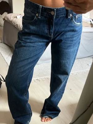 Mörkblå raka jeans Zara  - Snygga mörkblå jeans med rak passform och klassisk femficksdesign. Jeansen har normal midja och stängs med knapp och dragkedja. Perfekta för en avslappnad och trendig look. Materialet är klassisk denim i bomull. 