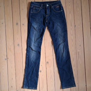 Nichol Judd jeans med låg midja - Mörkblå lågmidje jeans med raka ben. Midja ca 69 cm (ca 34,5 rakt över). Benlängd ca 79 cm.