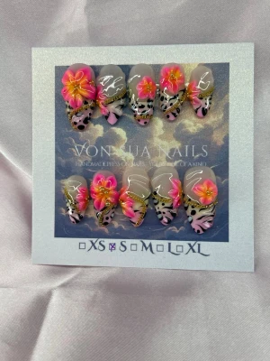 FrankieSoft (S);Medium Almond - Unika handgjorda press-on naglar med tiger/leopardmönster i svart och rosa, dekorerade med stora 3D-blommor i neonrosa och orange samt gulddetaljer. Formen är medium lång almond och designen är handgjord för en riktigt statement-look. Inspo av konstnären Lisa Frank, S: 15 mm, 11,5 mm, 12 mm, 11 mm, 9 mm 