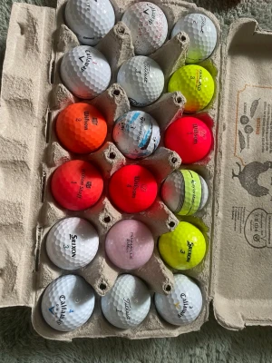 Stort parti golfbollar i olika färger - Säljer ett stort gäng golfbollar i blandade färger som vitt, gult, orange, rosa och rött. Flera olika märken syns, bland annat Titleist, Callaway, Srixon och Wilson. Perfekt för dig som vill fylla på golfväskan med många bollar i olika färger och stilar.