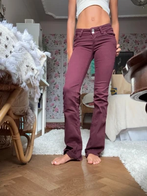 Lågmidjade vinröda jeans - Snygga vinröda jeans med bootcut. Jeansen har lågmidja. Perfekta för dig som vill ha en trendig och bekväm look. De är från Nelly i jätte bra skick. Stl 32