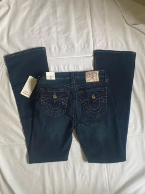 True Religion Becca mörkblå bootcut jeans  - Säljer ett par mörkblå jeans från True Religion med bootcut-modell. Så snygga! Prislappen kvar aldrig använda! Skriv ifall ni har några frågor🥰Nypris: 1200 kronor