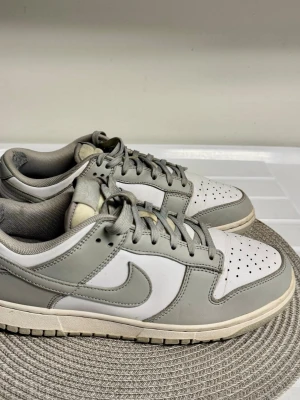 Nike Dunk Low gråvita sneakers - Snygga Nike Dunk Low sneakers i grått och vitt storlek 43.