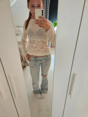 Ljusblå jeans - Säljer ett par ljusblå jeans med bootcut-passform och slitningar vid knäna. Jeansen har klassiska fyra fickor och låg midja. Säljer p.g.a för små