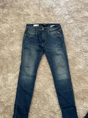 Replay jeans - Snygga mörkblå slim fit jeans med klassisk femficksdesign och diskreta slitningar framtill. Jeansen har normal midja och smala ben, perfekta till vardagslooken. Materialet är stretchigt denim för extra komfort.