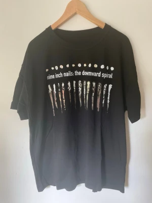 Classic Nine Inch Nails T-Shirt - Size XL - Classic Nine Inch Nails T-Shirt. No tag but fits like a size XL, oversized and boxy fit. Great condition, no flaws or damage. Size measurements are L - 70cm, W - 58cm. Buyer pays for all shipping costs. All items sent with tracking number.   No swaps, no trades, no offers.  No 100 questions from 14 year olds either, it’s a cotton tee, it’s cheap, buy it!