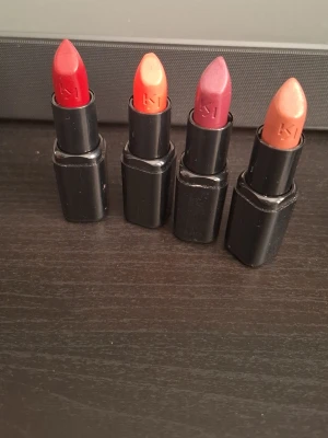 Fyra KIKO läppstift i olika färger - Säljer fyra KIKO Smart Fusion Lipstick i snygga färger: klassiskt röd, orange, mörkröd och nude. Alla har svart hylsa och krämig formula som ger ett jämnt resultat på läpparna. Perfekt för dig som vill variera din look med olika nyanser.