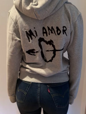 'Mi Amor' Grå hoodie - Snygg grå (Mi Amore) 💘hoddie från Mira Paris i nyskick. Köpt från zalando i storlek (S). Knappt använd. Trycket på ryggen är inborderat. 