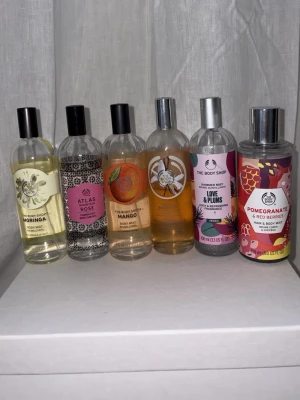 The Body Shop body mists 6-pack - Säljer ett set med sex olika body mists från The Body Shop: Moringa, Atlas Rose, Mango, Vanilla, Love & Plums samt Pomegranate & Red Berries. Flaskorna är genomskinliga med färgglada etiketter och svarta eller silverfärgade lock. Perfekt för dig som gillar fräscha och fruktiga dofter. Ingen är helt full men finns en del kvar! Och doftar verkligen super gott men har alldeles för mycket parfymer att använda upp 😩🩷🥰