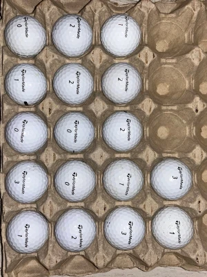 20 TaylorMade vita golfbollar  - Säljer 20 vita golfbollar från TaylorMade, placerade i en kartong för förvaring. Bollarna har olika siffror tryckta på sig och är tillverkade i slitstarkt material med klassisk dimple-design för optimal flygprestanda. Alla bollar är tvättade och spelas med som nya.