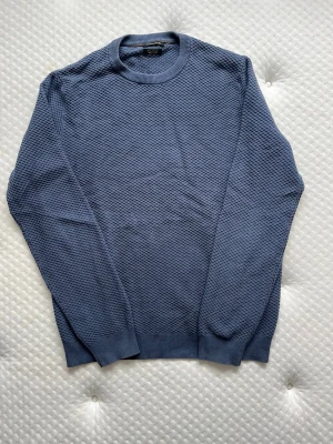 Massimo Dutti stickad mörkblå tröja  - Superfin långärmad stickad tröja från märket Massimo Dutti, av en bomull och kashmir blandning (96% bomull, 4% Kaschmir). Tröjan är mörkblå vilket tydligast syns på bild 2. Tröjan är i fint skick, enda skavanker är ytterst lite blekning vid kanter såsom kragen (bild 5) samt ett väldigt litet hål vid ena armhålan (bild 6). Storlek M men upplevs lite mindre i storleken.