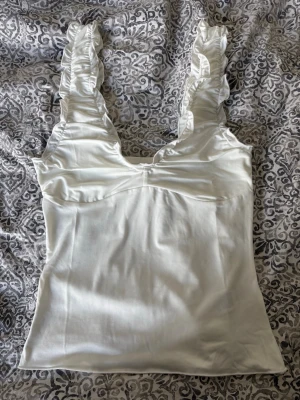 Vit linnetopp med volangaxelband - Snygg vit linnetopp från Nelly, helt oanvänd🌸