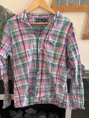 Rutig skjorta från Ralph Lauren L - Säljer en färgglad rutig skjorta från Ralph Lauren i storlek L. Skjortan har lång ärm, klassisk krage och knäppning framtill. Färgerna går i rosa, grön, blå och vit. Perfekt för dig som gillar en avslappnad men ändå stilsäker look.