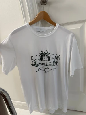 T shirt från palmers - Säljer en vit t-shirt från Palmers med ett unikt grafiskt tryck framtill i svart och grönt, perfekt för en chill och stilren look. Köpt på Vallgatan 12 Göteborg