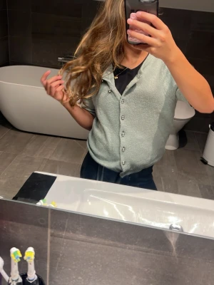 Ljusgrön kortärmad kofta från H&M - Superfin ljusgrön kofta från H&M med korta ärmar och snygga silverknappar framtill. Mjuk stickad känsla och avslappnad passform, perfekt att slänga över ett linne eller t-shirt. Enkel att styla till både jeans och kjol.