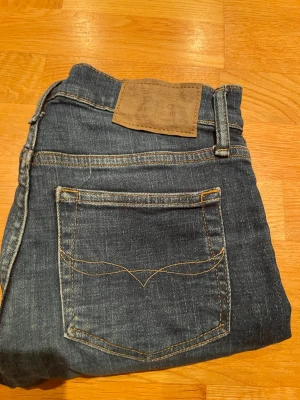 Mörkblå  Ralph lauren raka jeans med kontrastsömmar - Säljer ett par mörkblå jeans från Ralph lauren med raka ben och snygga kontrastsömmar. Jeansen har klassisk femficksdesign och dekorativ söm på bakfickan. Perfekta till vardags för en avslappnad men stilren look.
