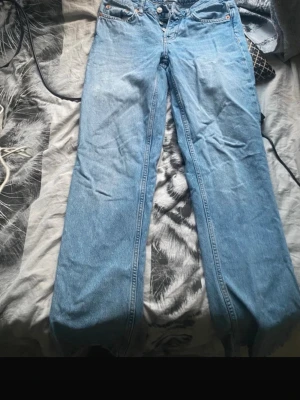 Ljusblå raka jeans - Säljer ett par ljusblå jeans med rak passform ( inte skinny) och klassisk femficksdesign. Jeansen har låg midja och är tillverkade i ett robust denimtyg. Perfekta för en avslappnad och trendig look.