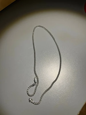 Silverfärgat kedjehalsband - Snyggt halsband i silverfärg med en klassisk kedjedesign. Halsbandet har en enkel och stilren look som passar till många olika stilar. Låset är av karbinmodell och kedjan har en diskret glansig finish.