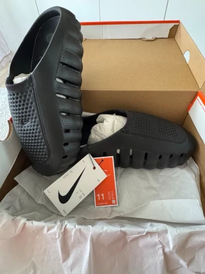 Nike mind 001 - ÄKTA, Har kvitto och allt bevis i appen också vad än du behöver för bevis Nike Mind 001 – Nya.                                                            Säljer mina Nike Mind 001 pga för små för mig. Passar dig som har storlek 44–44,5 perfekt. Skorna är i nyskick, . Det är Nikes "pregame/recovery"-mule med 22 st sensoriska foam-noder under foten som aktiverar hjärnans sinnesområden. Vattenavvisande ovandel, mjukt skum i mellansulan och lätt att slänga på sig. 