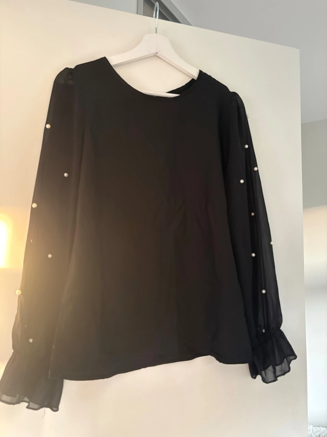 Svart blus med pärldetaljer