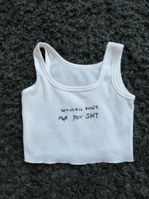 Vitt linne ”women don’t Owe you shit” - Vitt kort linne från Cider ”women don’t Owe you shit”