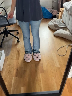 Ljusblå bootcut jeans med slitning - Säljer ett par ljusblå bootcut jeans med en liten slitning på vänster lår. Jeansen har klassisk femficksdesign, normal midja och stängs med knapp och dragkedja. Perfekta för en avslappnad och trendig look.