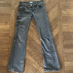 Grå jeansbyxor från Gina Tricot - Säljer ett par grå jeansbyxor från Gina Tricot i storlek 158. Jensen är utsvängda och lågmidjade. Dom är i storlek 158 men är ifrån Gina Young tall så skulle säga att dom skulle passa perfekt om man är runt 165cm är även lite korta på mig som är 168cm💖