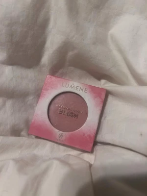 Lumene Natural Glow Blush - Naturligt rouge från Lumene i nyansen 2 Rosy Glow. Kommer i en fyrkantig förpackning med rosa och vit design. Pudret har en mjuk, rosatonad färg som ger kinderna en fräsch lyster. Vegansk formula. Har använt den typ 5 gånger.