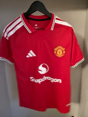 Manchester United Hemma 26/27 - Helt ny och trendig Manchester United 2026 / 2027 säsongs Hemma version fotbollströja. Nypris runt 1099kr. Passformen på tröjan är som en oversized t-shirt i storlek S. Tröjan kommer med original förpackning och skickas i förstärkt påse för att hindra skador eller slit under frakt. Kontakta vid funderingar, och kolla min profil om du vill se andra tröjor. 