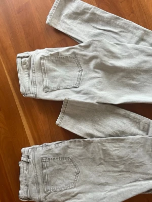 Ljusgrå raka jeans - Säljer ett par ljusgrå jeans med rak passform och klassiska bakfickor. Jeansen har normal midja och är tillverkade i ett mjukt denimtyg. Perfekta för en avslappnad och trendig look. Ett par är i xxs/xs och de andra är i 152. 