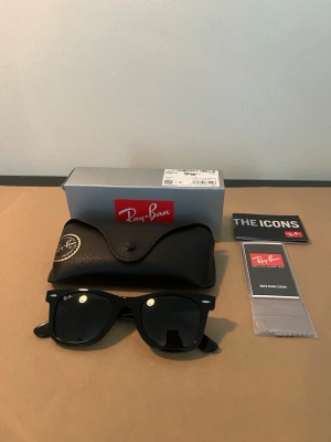 Helt nya Klassiska Ray-Ban Wayfarer Solglasögon, Först till kvarn! - Säljer ett par helt nya klassiska Ray-Ban Wayfarer solglasögon. Modellen är en modern ikon från Ray-Ban med en trendig design. Först till kvarn gäller!  De är handgjorda i Italien.  Kommer i svart färg med och är i perfekt skick.   Tillbehör som etui, putsduk och originalkartong medföljer.  Nypris: 2000+ kr från Zalando.