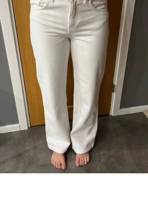 Vita raka jeans med hög midja, aldrig använda, stl 36 - Säljer ett par helt nya vita jeans med rak passform och hög midja. Jeansen har klassiska fem fickor och stängs med dragkedja och knapp. Materialet är kraftigt denim som ger en snygg siluett. Perfekta för dig som gillar en clean och stilren look.