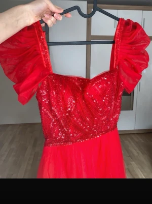 Röd paljettklänning med puffärmar - ❤️ Elegant röd maxiklänning, perfekt för bal, student, fest eller andra speciella tillfällen.  ✨ Detaljer: Glittrig paljettöverdel Romantiska puffärmar i tyll Justerbar snörning i ryggen för bättre passform Lång, luftig tyllkjol Använd endast en gång I mycket fint skick Ärmarna kan bäras både på axlarna eller nedhasade (off shoulder), så du kan variera stilen.  Säljs på shein för 1631kr som ni ser på sista bilden.  Skicka gärna ett meddelande om du har frågor eller vill se fler bilder. 😊