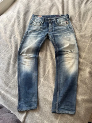 Replay jeans  - Säljer ett par blå replay anbass jeans med snygga slitningar och tvättade detaljer på både fram- och baksida som bara går att få genom år av användning. Storlek 30/30. Till skillnad från anbass jeans som säljs idag har dessa riktigt jeans material.  Bara att höra av sig vid mått eller frågor. 