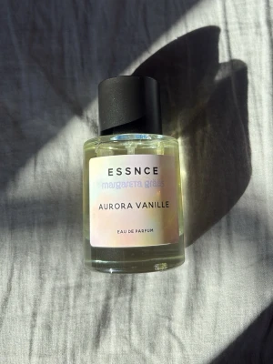 Aurora Vanille parfym från Essnce - Aurora Vanille från Essnce är en Eau de Parfum i en stilren, rund glasflaska med svart lock. Etiketten har en mjuk pastellfärg och parfymen har en varm, vaniljig doftprofil. Perfekt för dig som gillar söta och eleganta dofter. Priset kan diskuteras 