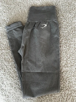 Träningstights gymshark - Ljusgråa tights från Gymstark i storlek M. Nya och oanvända, men utan prislapp. Säljes då de inte kommer till användning.  Katt finns i hemmet, produkten rollas av så gott det går.