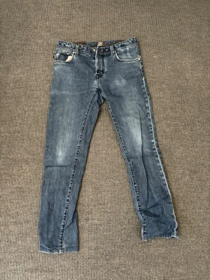 Tramarossa Jeans - Snygga blå slim fit jeans från Tramarossa med klassisk femficksmodell och diskreta slitningar. Jeansen har detaljerade sömmar och patchar på insidan samt knappgylf. Tillverkade i mjuk denim med stretch för extra komfort. Skick 8/10 enda dåliga är att knappen har gått av men med ett bälte märks det knappt!🙌🙌