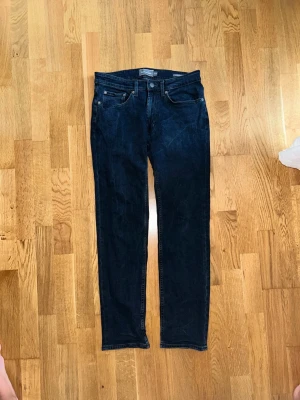 Mörkblå raka jeans - Snygga mörkblå jeans med rak passform och klassisk femficksdesign. Jeansen har normal midja och är tillverkade i ett denimtyg med lätt stretch. Perfekta för en avslappnad och stilren look.
