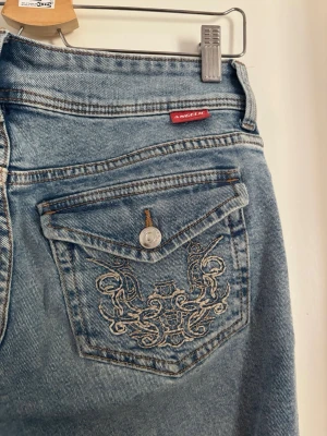 Bootcut jeans - Ljusblå bootcut jeans med broderier på bakfickorna från HM i storlek 38💕