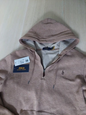 ÄKTA Ralph Lauren hoodie - Säljer en beige hoodie från Polo Ralph Lauren med halv dragkedja och klassisk huva. Står att det är storlek S fast passar XS