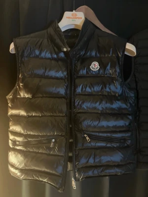 Moncler väst - Svart Moncler väst. Man får med de på sista bilden, Storlek 2=S/M passar mig skitbra och jag är 175. Dragkedjan är lite trög. Obs: inte mina bilar då jag inte fick lägga upp mina egna😊