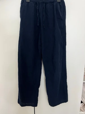 Mörkblå linnebyxor från Gina Tricot - Säljer ett par jättefina mörkblå/navyblå linnebyxor från Gina Tricot i storlek XS. De är lågt midjade och sitter väldigt fint på kroppen. Färgen är mörkblå även om den kan se lite ljusare ut på bilderna. De är köpta från Gina Tricot för ca 300 kr och är i fint skick. Säljer dem för 150 kr